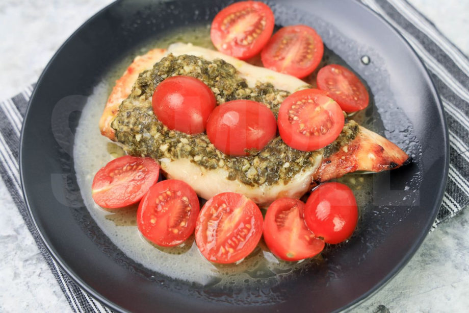 The Olive Garden Copycat Grilled Chicken Margherita comes on a gray striped napkin on a gray plate with a marble backdrop.