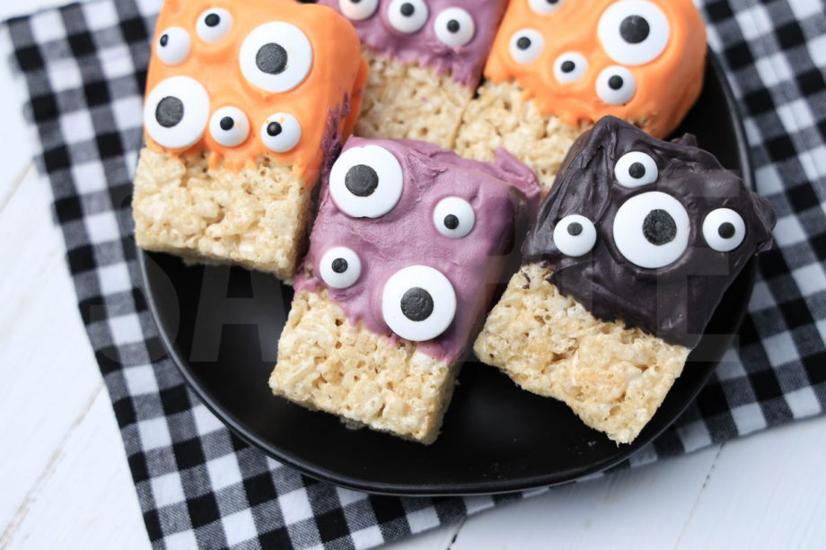 The Monster Rice Krispy Treats comes on a white plate with a plaid napkin on a white wood backdrop.