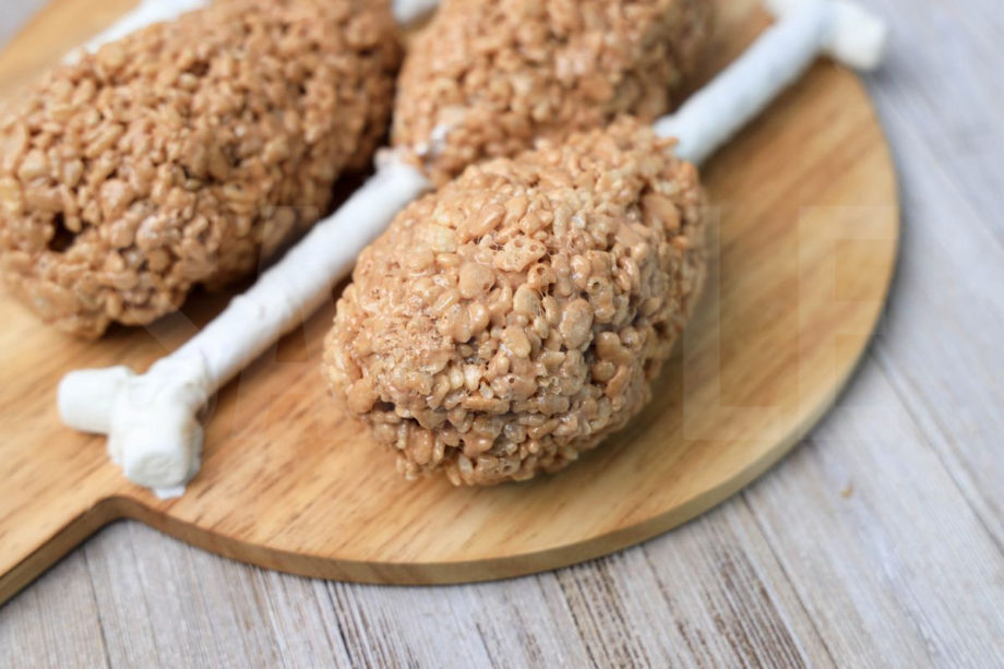 The Turkey Leg Rice Krispies Treats comes on a wood board on a rustic wood backdrop.