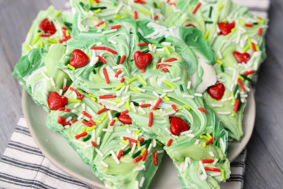 The Grinch Bark comes on a white plate with a white striped napkin on a gray wood backdrop.