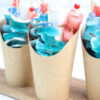 The Shark Candy Cups comes in a brown fry cup with white wood backdrop.