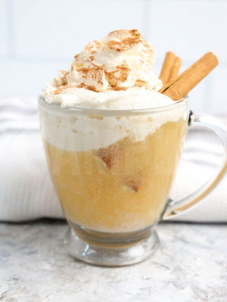 The Apple Cider Float comes in a glass with handle on a with marble wood backdrop.