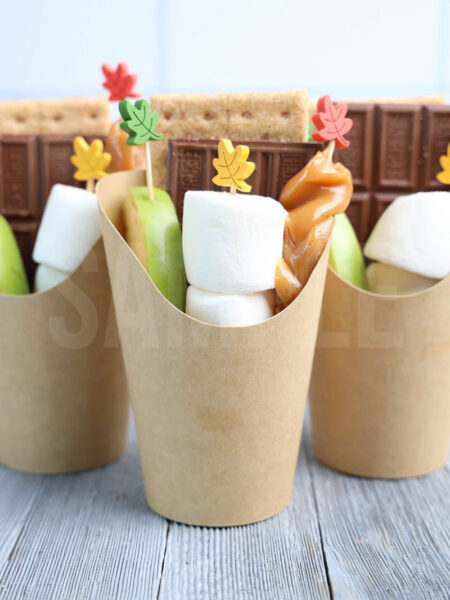 The Caramel Apple S'mores Cups comes in a brown fry cup with gray wood backdrop.