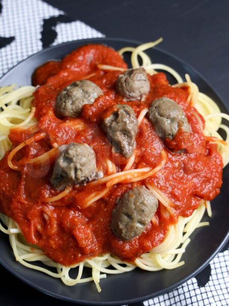 The Horrific Spaghetti and Meatballs come on a dark gray plate with black wood backdrop.