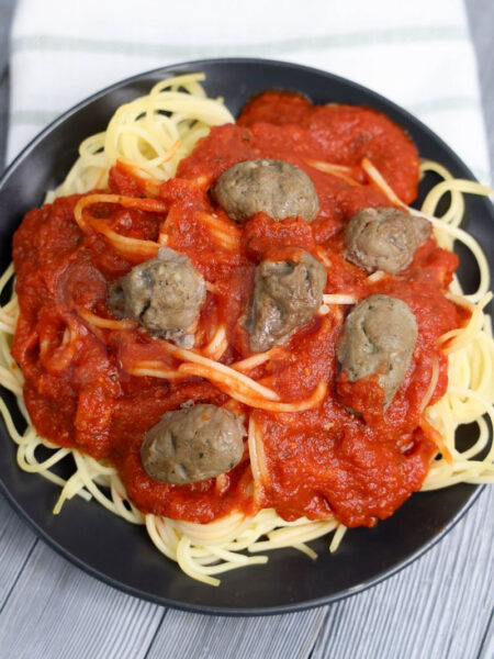 The Horrific Spaghetti and Meatballs come on a dark gray plate with gray wood backdrop.